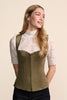 A green faux-suede vest with a front zipper over a white lace short-sleeve top